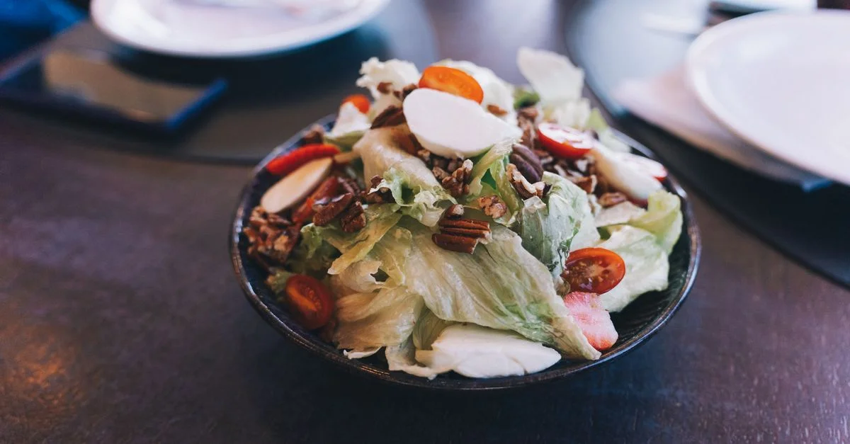 Délicieuse salade fraîche avec des tomates cerises, des noix et de la mozzarella dans un bol.